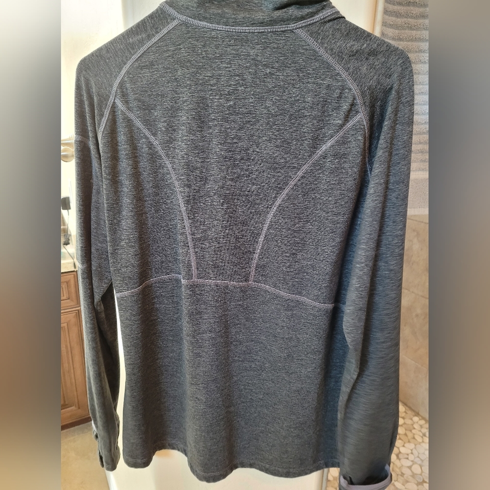 A grey Kirkland long-sleeve shirt With neck zipper and arm pocket with zipperTh